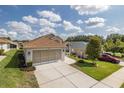Single-story home featuring a well-maintained lawn, long driveway, and an attached two-car garage at 284 Quane Ave, Spring Hill, FL 34609
