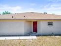 Rear exterior view showcasing a sturdy roof, minimal landscaping, and a traditional red door for a touch of color at 3885 Crossline Dr, Spring Hill, FL 34609