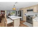 Open concept kitchen features an island and stainless steel appliances at 4932 Gaslight Ave, Holiday, FL 34690