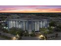 Condo building with waterfront access, swimming pool, and mature landscaping at dusk at 4939 Floramar Ter # 902, New Port Richey, FL 34652