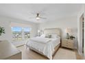 Bright main bedroom features neutral tones, a ceiling fan, and a large window providing plenty of natural light at 4939 Floramar Ter # 902, New Port Richey, FL 34652