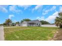 Charming single-story home featuring a two-car garage, covered front porch, and a large front yard at 5214 Idlewild St, New Port Richey, FL 34653