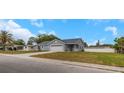 Charming single-story home featuring a two-car garage, covered front porch, and a large front yard at 5214 Idlewild St, New Port Richey, FL 34653