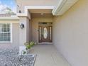 Inviting front porch with a decorative front door and manicured landscaping at 6076 Shiprock Ave, Spring Hill, FL 34608