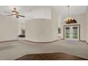 Open-concept living area features plush carpeting, a decorative chandelier, and natural light at 642 Erin Way, Brooksville, FL 34601