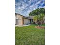 Inviting home exterior with lush green lawn and mature palm trees at 6425 Thicket Trl, New Port Richey, FL 34653