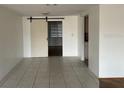 Bright dining room with tiled floors and a sliding barn door to another room at 7331 Sandalwood Dr, Port Richey, FL 34668