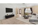 Bright living room featuring tile floors, a modern black cabinet, and a white sofa at 7464 Acorn Cir, Spring Hill, FL 34606