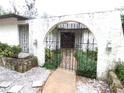 A gated entryway with arched stonework, black wrought iron, and a walkway to the front door at 7632 Lake Forest Cir, Port Richey, FL 34668
