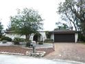 Charming single-story home with rock gardens, wrought iron entry, two car garage, and well manicured lawn at 7632 Lake Forest Cir, Port Richey, FL 34668