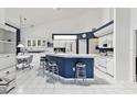 Bright, well-lit kitchen features white appliances and cabinetry contrasting with a navy blue breakfast bar at 8001 Summerbreeze Ter, Spring Hill, FL 34606