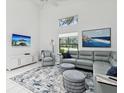 Modern living room features high ceilings, neutral tones, tile floors, and large windows allowing ample natural light at 8001 Summerbreeze Ter, Spring Hill, FL 34606