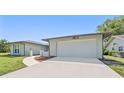 The home's driveway leads to an attached two-car garage, framed by a well-kept lawn at 8749 Aruba Ln, Port Richey, FL 34668
