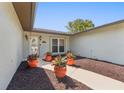 The home's entrance has a well-lit walkway, beautiful landscaping, and a glass front door at 8749 Aruba Ln, Port Richey, FL 34668