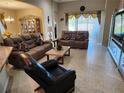 Inviting living room showcasing comfortable seating, decorative accents, and natural light streaming through the large windows at 954 Old Windsor Way, Spring Hill, FL 34609