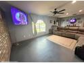 Open living room with a comfortable sectional sofa, ceiling fan, and large window at 11080 Jackdaw Rd, Weeki Wachee, FL 34614