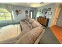 Cozy living room featuring a large sectional sofa and ample natural light at 11080 Jackdaw Rd, Weeki Wachee, FL 34614