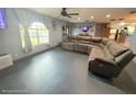 Spacious living room with dark grey floors, large window, and sectional sofa at 11080 Jackdaw Rd, Weeki Wachee, FL 34614