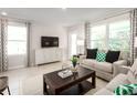 Bright living room featuring modern furnishings, large windows, and stylish decor, creating a comfortable ambiance at 11410 Spectacled Dr, New Port Richey, FL 34654