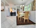 Bright dining room with a view to the kitchen, chandelier, and seating for four at 11631 Bayonet Ln, New Port Richey, FL 34654