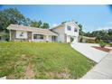 Charming two-story home with a spacious driveway, stone accents, and green lawn at 12106 Bear Creek Ln, Hudson, FL 34667