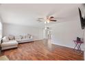 Spacious living room with beautiful hardwood floors, a comfortable couch, and ceiling fans at 12106 Bear Creek Ln, Hudson, FL 34667
