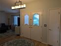 Welcoming entryway featuring double front doors with decorative glass panels and modern light fixture above round area rug at 1221 Etta Ave, Spring Hill, FL 34609