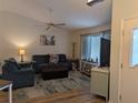 Inviting living room with plush blue seating, wood laminate floors and a large window that fills the space with natural light at 1221 Etta Ave, Spring Hill, FL 34609