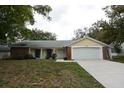 Charming single-story home features a two-car garage and well-maintained front yard at 12411 Yorktown Ln, Hudson, FL 34667