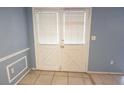 Hallway view of french doors in a living room with gray-blue walls at 12411 Yorktown Ln, Hudson, FL 34667