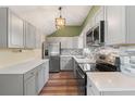 Modern kitchen with stainless steel appliances, gray cabinets, and stylish backsplash at 12516 Cobble Stone Dr, Hudson, FL 34667