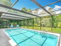Stunning screened-in pool area with an oversized layout provides a refreshing outdoor oasis at 13003 Sandburst Ln, Hudson, FL 34667