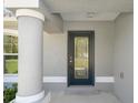 Close-up of the front door, framed by a pillar, featuring decorative glass and modern hardware at 13343 Sampson Ave, Brooksville, FL 34614