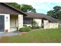 Inviting home entrance with stone accents, well-maintained landscaping, and a cozy front porch at 13425 Bonita Ave, Spring Hill, FL 34609