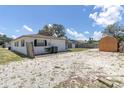 Exterior shot of the back of the house showing the stone landscaping and a wooden shed at 1402 Tallahassee Dr, Tarpon Springs, FL 34689