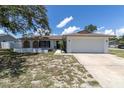 A well-maintained home showcasing a clean white exterior and a spacious two-car garage at 1402 Tallahassee Dr, Tarpon Springs, FL 34689