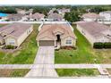 Aerial view of a home with a backyard pool, well-maintained lawn, and a surrounding neighborhood at 15205 Durango Cir, Brooksville, FL 34604