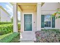 Inviting front door with elegant columns, lush landscaping, and a window with charming shutters at 15846 Stable Run Dr, Spring Hill, FL 34610