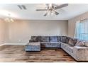 Spacious living room featuring sleek hardwood floors and a large comfortable sectional sofa at 15846 Stable Run Dr, Spring Hill, FL 34610