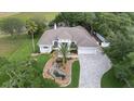 Stunning exterior elevation view with manicured landscaping and a winding driveway that leads up to a 2 car garage at 18644 Autumn Lake Blvd, Hudson, FL 34667