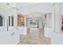 Open-concept living space featuring tile floors, columns, fireplace and views of the outdoor pool area at 18644 Autumn Lake Blvd, Hudson, FL 34667