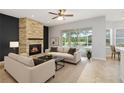 Bright living room featuring a stone fireplace, neutral furnishings, and a large window with a golf course view at 18644 Autumn Lake Blvd, Hudson, FL 34667