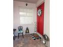 Charming front porch with a bright red door, decorated with a floral wreath and 'Gather' sign at 20720 Eustis Rd, Land O Lakes, FL 34637