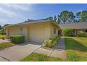 Charming home with a two-car garage, and well-maintained landscaping, situated on a green lawn and sunny skies at 3274 Lori Ln # 2, New Port Richey, FL 34655