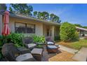 Charming outdoor patio seating area with wicker furniture, potted plants, and brick pavers, perfect for relaxation at 3274 Lori Ln # 2, New Port Richey, FL 34655