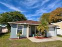 Cozy single-story home with a well-manicured lawn, attached garage, and a welcoming front patio area at 3315 W Saint John St, Tampa, FL 33607
