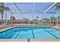 Screened-in pool provides a refreshing escape with vibrant floral accents and clear blue skies at 3352 Gulfview Dr, Hernando Beach, FL 34607