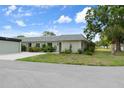 Single-story home with colorful landscaping, lush green lawn, and mature trees at 3544 Teeside Dr # 1, New Port Richey, FL 34655
