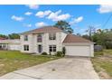 Charming two-story home with an attached garage and a long, inviting driveway and blue front door at 4148 Landover Blvd, Spring Hill, FL 34609