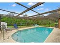 Large screened-in pool area with plenty of room to relax and enjoy outdoor living and lush landscape at 4190 Lema Dr, Spring Hill, FL 34609
